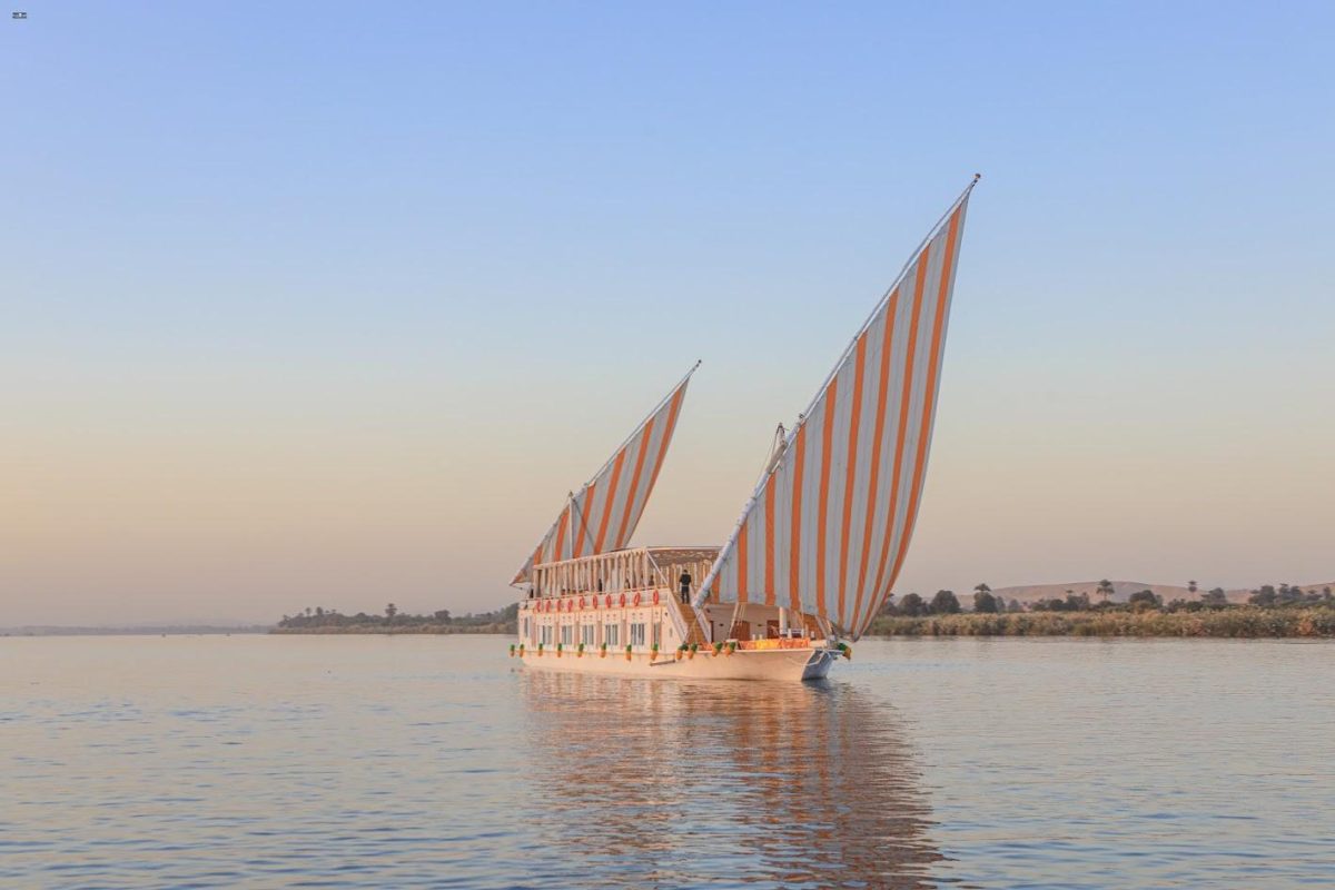 Private Dahabiya Nile Cruise boat sailing past ancient Egyptian temples on a 10-day luxury tour from Luxor to Aswan.