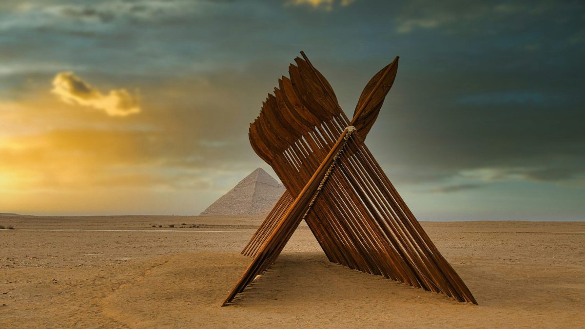 View of the Pyramids of Giza at sunset with the Nile River in the background.