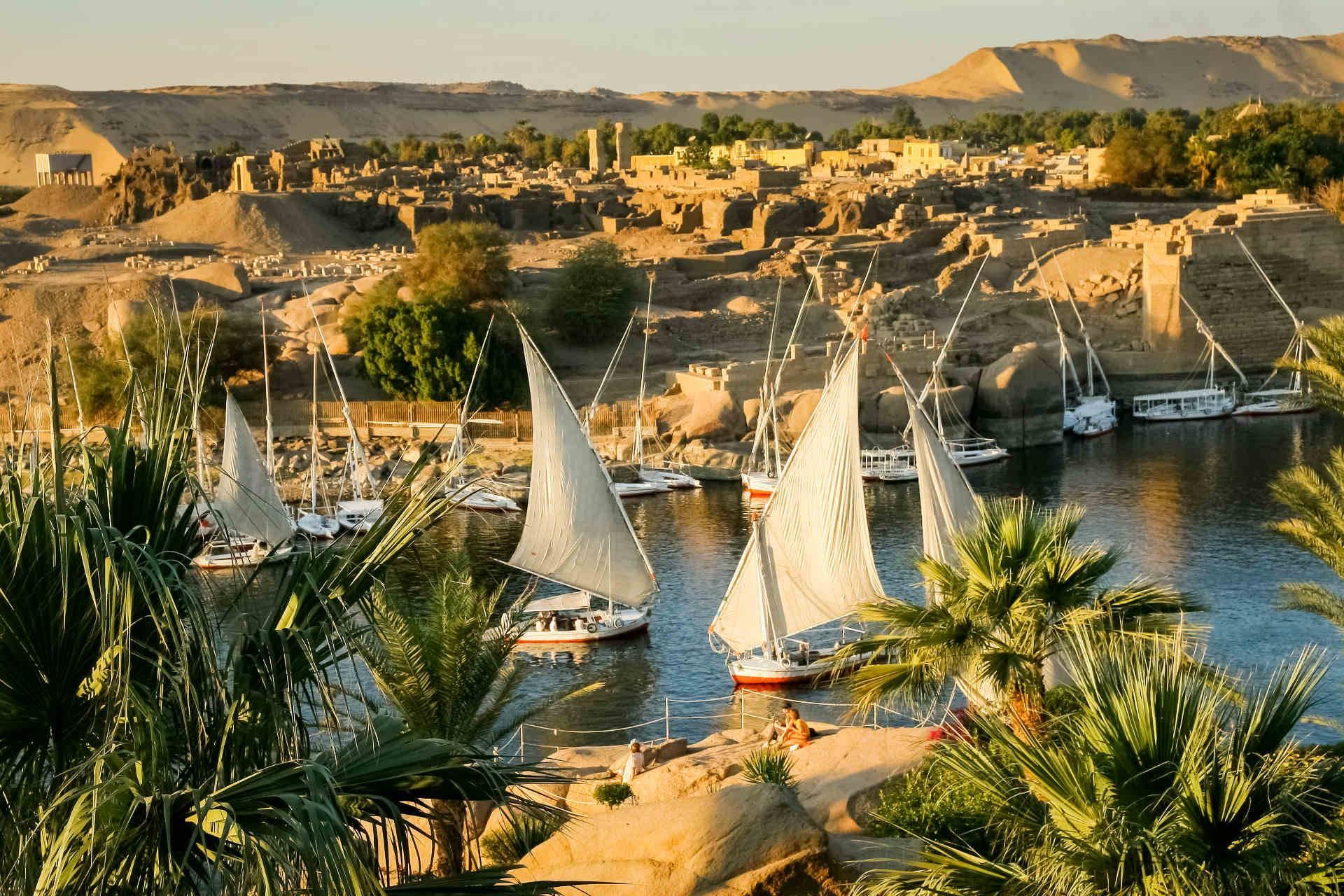 Traditional wooden felucca boat sailing on the Nile River at sunset in Aswan, Egypt, with MSM Travel Egypt.