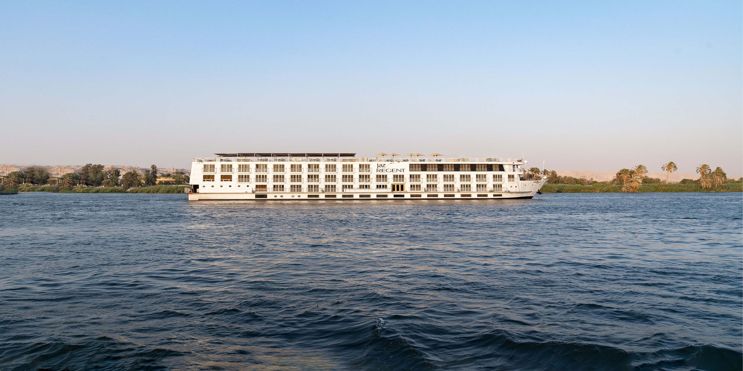 Luxury Nile cruise sailing between Luxor and Aswan with scenic views of the Nile River.