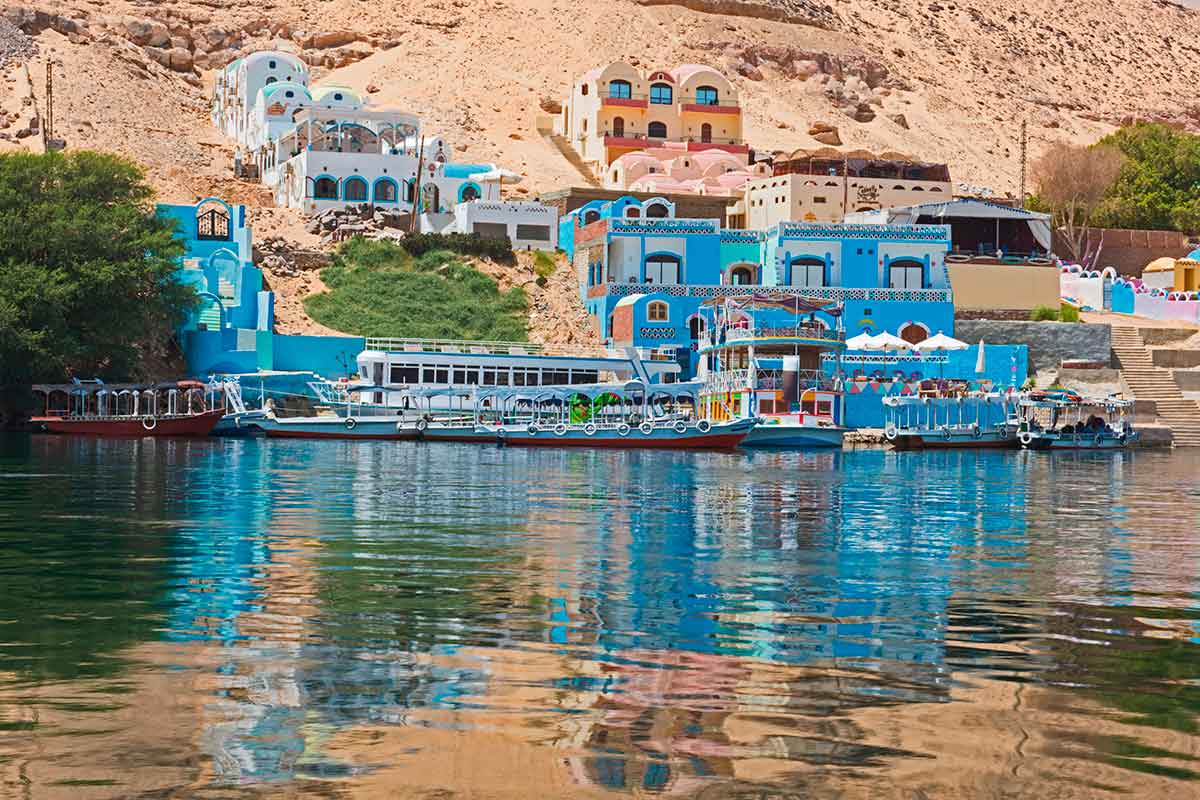Colorful traditional Nubian houses on the banks of the Nile River during a private boat tour in Aswan with MSM Travel Egypt.