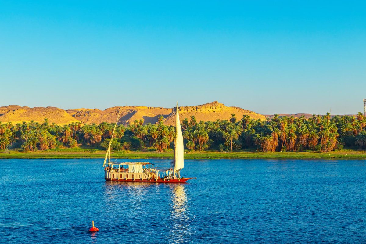 Dahabiya Nile cruise sailing on the Nile River at sunset near Aswan, Egypt