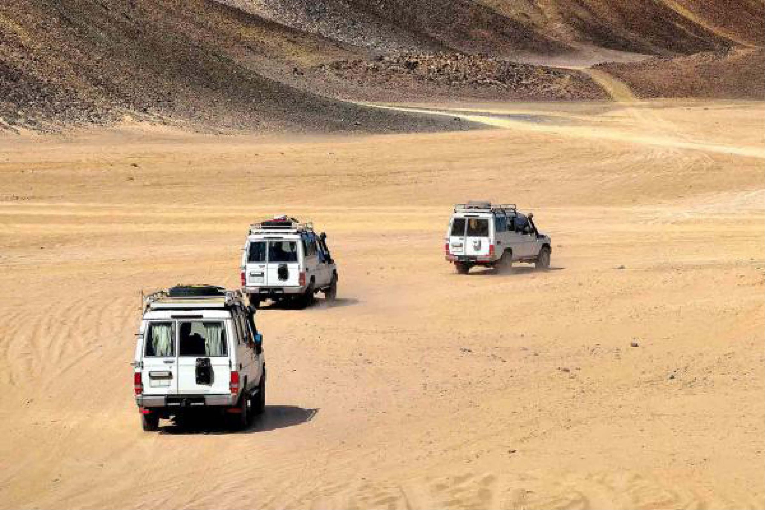 Hurghada desert safari quad bike at sunset with Bedouin village background