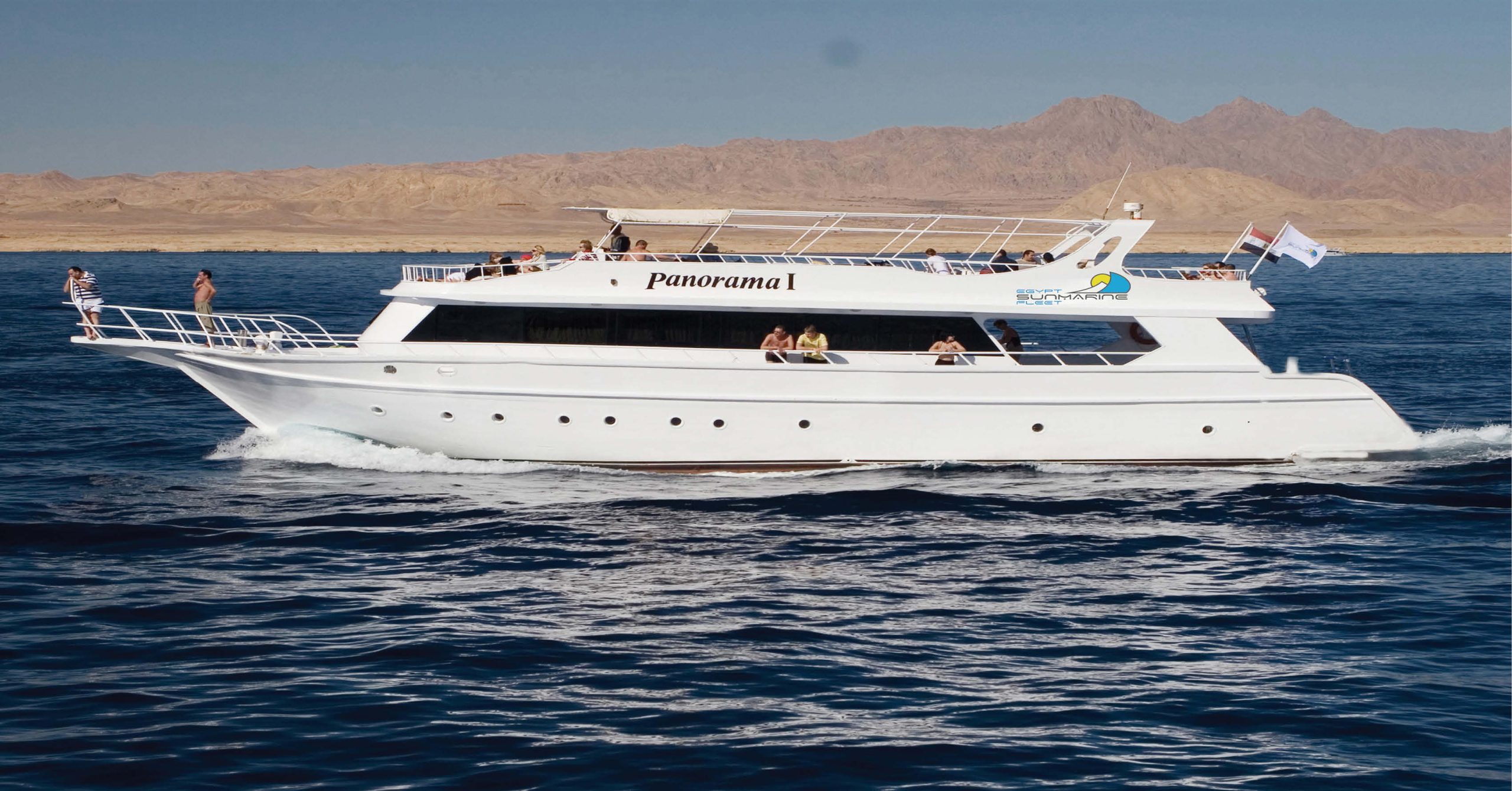 Classic Boat sailing on the Red Sea near Sharm El Sheikh with passengers enjoying the sun deck and clear blue waters.