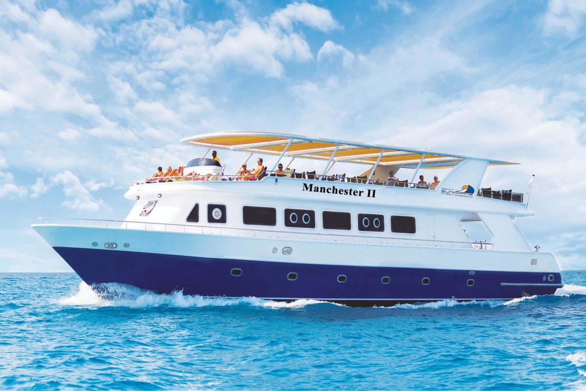 Elite VIP boat anchored at Orange Bay Island Hurghada with tourists snorkeling in the Red Sea.