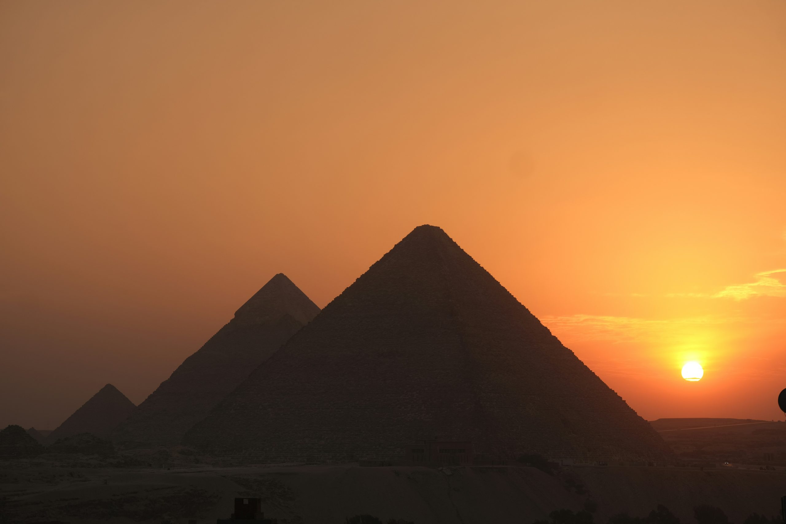 Tourists exploring the Pyramids of Giza under a clear blue sky
