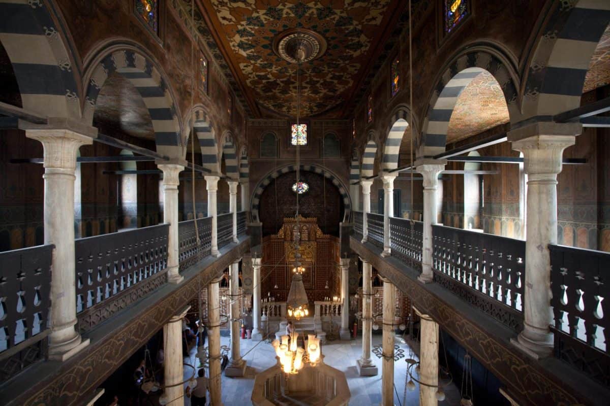 The interior of the Ben Ezra Synagogue in Old Cairo, showing the ornate marble stand, gold-patterned ceiling, and unique Coptic-influenced architecture.