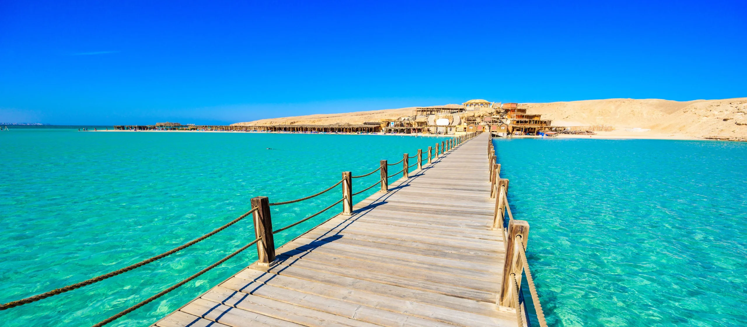A panoramic view of a luxury tour boat sailing on the bright turquoise waters of the Red Sea coast in Hurghada, Egypt.