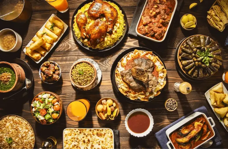 Overhead view of a lavish traditional Egyptian feast featuring roast chicken, rice dishes, mahshi, and various stews.