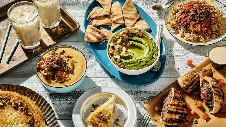 A vibrant spread of traditional Egyptian street food including Koshari, Ta'ameya, Hawawshi, and fresh juices.
