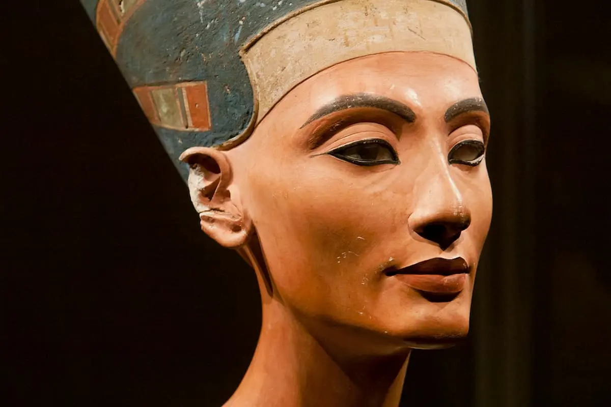 Queen Nefertari standing beside Ramesses II in ancient Egyptian wall art