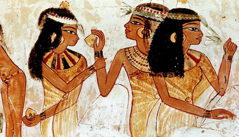 Detail of an ancient Egyptian tomb painting showing female musicians and noblewomen wearing formal wigs, floral headbands, and broad collars at a banquet.